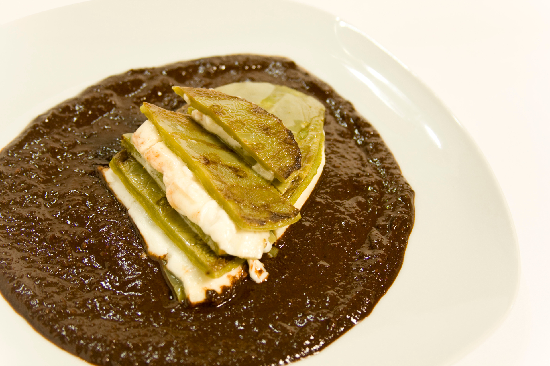 Grilled nopales and cheese served over mole
